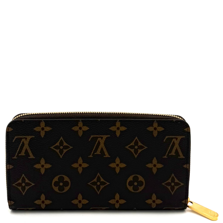 A Louis Vuitton monogram canvas zip-around wallet in dark brown with gold-tone hardware and a gold zipper pull, shown on a white background.