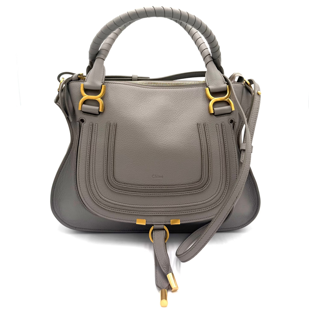 A gray leather handbag with structured double top handles, gold-tone hardware, and a matching shoulder strap, photographed against a clean white studio background.